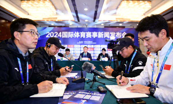 体育新闻发布现场记者正在记录赛事信息
